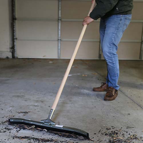 Long wooden cleaning handle attached to floor squeegee