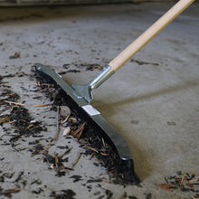 Load image into Gallery viewer, Heavy-duty floor squeegee moving debris across concrete surface