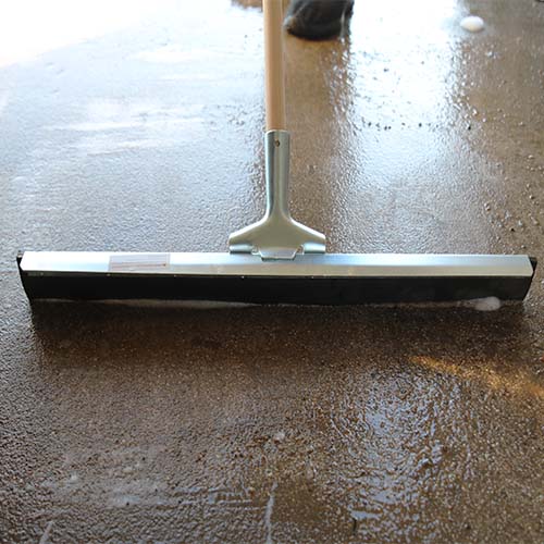 Durable rubber squeegee blade insert on steel frame cleaning floor liquid
